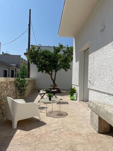 a patio with a bench and a table and a tree at Terra De Mare in Palmariggi