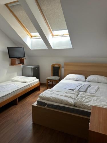 sypialnia z 2 łóżkami i telewizorem w obiekcie Pokoje Gościnne Rybitwa w Karwii