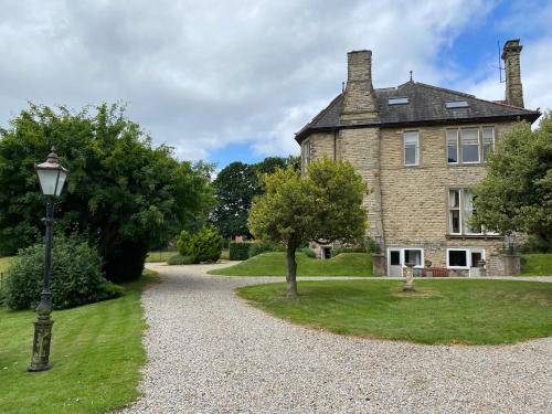 ein altes Haus mit Straßenbeleuchtung davor in der Unterkunft Bellfield Country Suites in Masham