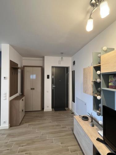 sala de estar con paredes blancas y suelo de madera. en Azzurro Apartment, en Sibiu