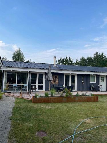 una casa con un patio con una casa en Really Nice And Big Summerhouse Close To Roskilde Fjord, en Ølsted