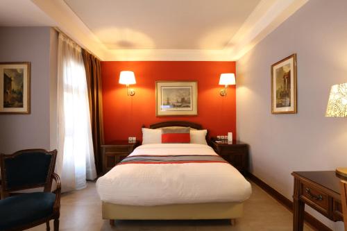 a bedroom with red walls and a large bed at Hôtel Les Saisons in Casablanca