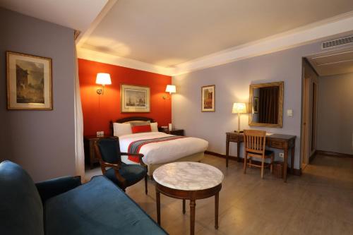 Habitación de hotel con cama y sofá en Hôtel Les Saisons, en Casablanca