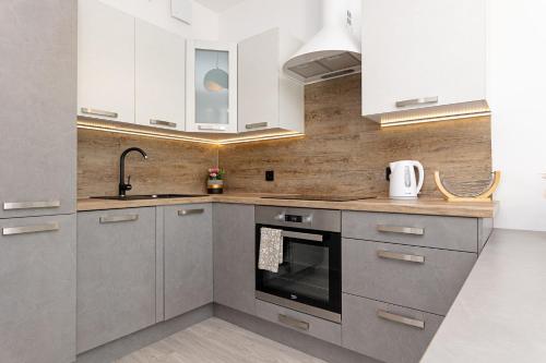 a kitchen with white cabinets and an oven at DreamHouse Apartament PORTOWY ul Wschodnia 12,Darłówko Wschodnie in Darłówko