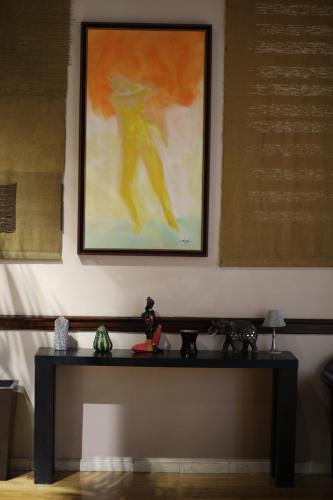 a table in a room with a painting on the wall at Hôtel Les Saisons in Casablanca