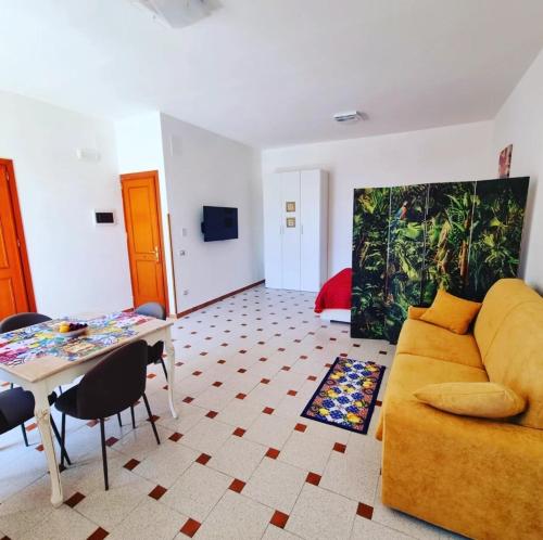 Casaafauka في كاريني: غرفة معيشة مع أريكة صفراء وطاولة