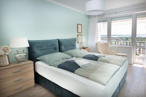 a bedroom with a bed and a large window at Panorama Residence in Balatonalmádi