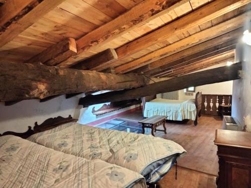 ein Schlafzimmer mit einem Bett in einem Zimmer mit Holzdecken in der Unterkunft DOSSENA Dimora Storica Al Lac Conte Tomaselli in Madonna della Costa