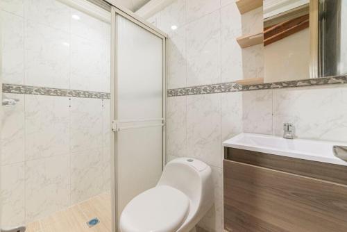 a bathroom with a toilet and a sink and a shower at Discover urban life in the heart of Medellin 202 in Medellín