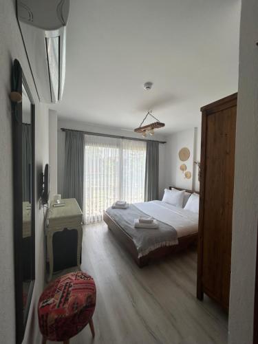 a bedroom with a large bed and a window at Pupa Alaçatı Butik Otel in Cesme