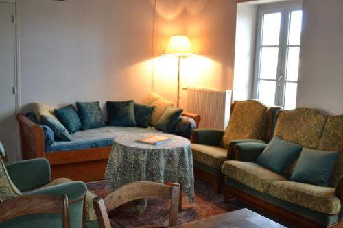 a living room with a couch and chairs and a table at La Barboulotte in Saint-Léger-Vauban
