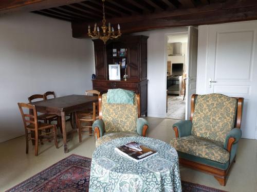 a living room with a table and chairs and a dining room at La Barboulotte in Saint-Léger-Vauban