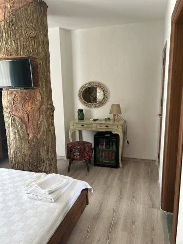 a bedroom with a bed and a table with a mirror at Pupa Alaçatı Butik Otel in Cesme