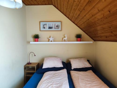 a bedroom with two beds and a wooden ceiling at Szigeti Apartmanház in Pécs