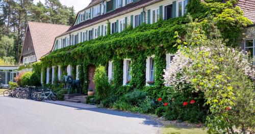an ivy covered building with bikes parked in front of it at Hotel Döllnsee-Schorfheide in Templin