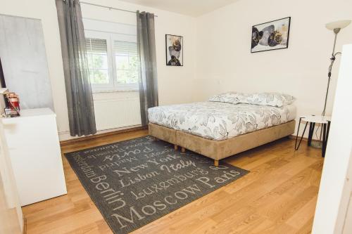 una camera con un letto e un tappeto su un pavimento in legno di Kuća za odmor BARBARELLA a Čakovec