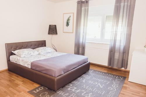 a bedroom with a bed and a window and a rug at Kuća za odmor BARBARELLA in Čakovec