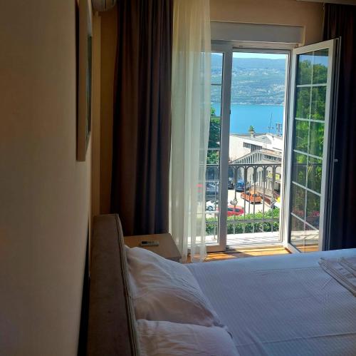a hotel room with a bed and a large window at Vila Oliva in Herceg-Novi