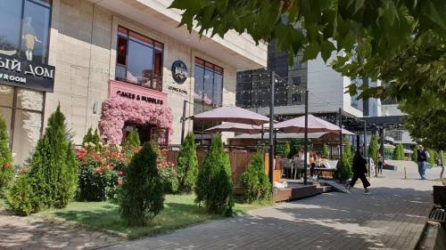 a building with tables and umbrellas on a street at Arbat apartment in the center city in Bishkek