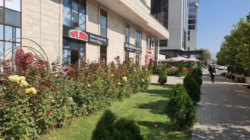 a building with a bunch of flowers in front of it at Arbat apartment in the center city in Bishkek