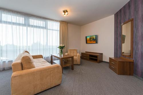 a living room with a couch and a mirror at Hotel Esperanto in Świdnica