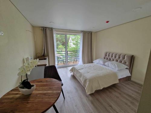 een slaapkamer met een bed, een tafel en een raam bij 2rest in Palanga
