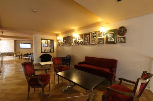 a living room with a couch and a table and chairs at Hôtel Les Saisons in Casablanca