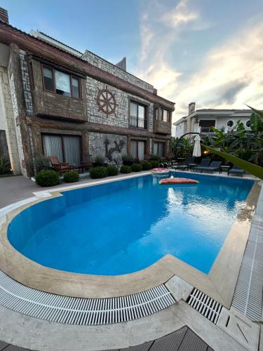 a large blue swimming pool in front of a building at Pupa Alaçatı Butik Otel in Cesme