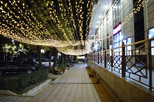 a street with lights hanging from a building at Arbat apartment in the center city in Bishkek