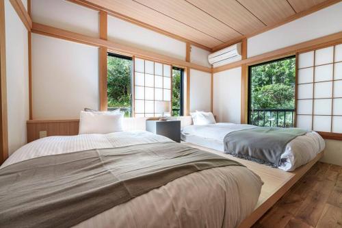 Ajiro的住宿－Villa Arancia，带窗户的客房内的两张床