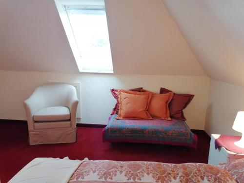 a attic room with a bed and a chair at Appartment Obergeschoß in Bad Zwischenahn