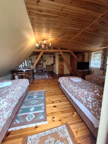 a room with two beds in a log cabin at GOŚCINIEC GŁODOWO in Ruciane-Nida