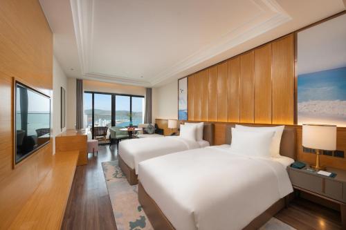 a hotel room with two beds and a living room at Grand Hyams Hotel - Quy Nhon Beach in Quy Nhon