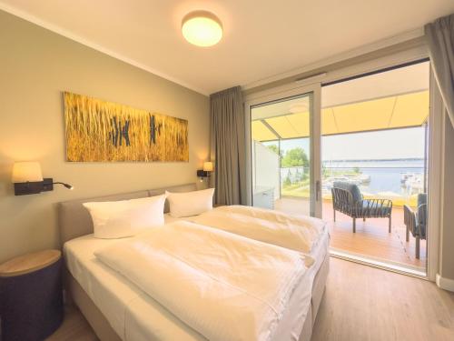 a bedroom with a bed and a sliding glass door at Appartements "Zum Leuchtturm" Hafen Rankwitz Insel Usedom in Rankwitz
