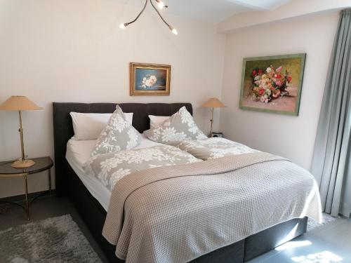 a bedroom with a bed with white sheets and pillows at Claas Villa am Meer in Bad Zwischenahn