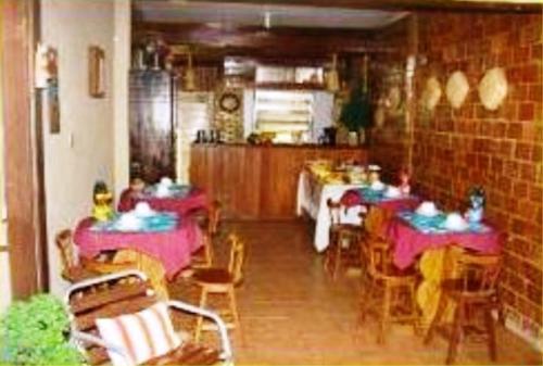 um restaurante com mesas e cadeiras com pessoas sentadas em Pousada Solar das Andorinhas em Fernando de Noronha