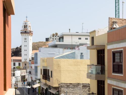 a city street with a lighthouse in the distance at Live Basilica Candelaria Beach & Balcony in Candelaria
