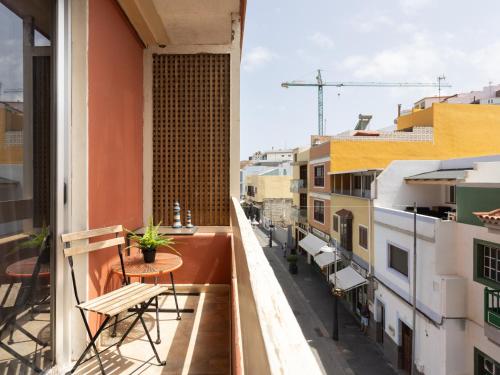 a balcony with a table and chairs and buildings at Live Basilica Candelaria Beach & Balcony in Candelaria