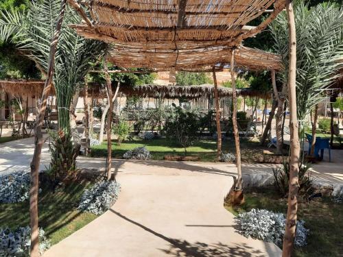 a wickerilion in a garden with palm trees at Moon_Valley_Siwa in Siwa