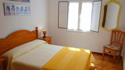 a bedroom with a bed and a chair and a window at Piso de Laura en primera planta in Lariño