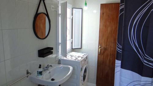 a bathroom with a sink and a mirror at Piso de Laura en primera planta in Lariño