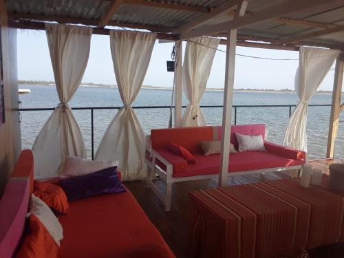 a boat with two beds and a couch on the water at Maison flottante in Ndangane