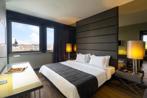 Habitación de hotel con cama grande y ventanas en HF Fenix Lisboa, en Lisboa