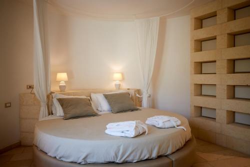 a bedroom with a bed with towels on it at Montiro' Hotel in Leuca