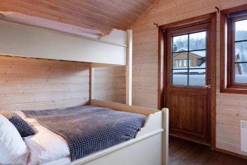 a bedroom with a bed in a wooden cabin at Filefjellstuene in Tyinkrysset