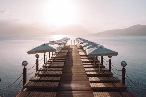 a row of umbrellas on a pier in the water at Casa De Maris Spa & Resort Hotel Adult Only 16 Plus in Marmaris