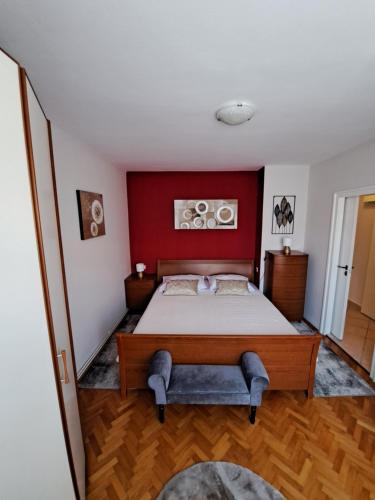 a bedroom with a bed with a red wall at Apartman Iadera in Zadar