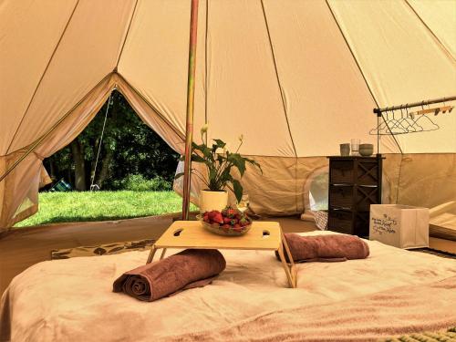 a tent with a table with a bowl of fruit on it at Mazury Glamping Kruklanki Polana Życzeń in Kruklanki