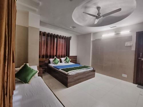 a bedroom with a bed and a ceiling fan at HOTEL SAI PRABHU INN in Shirdi
