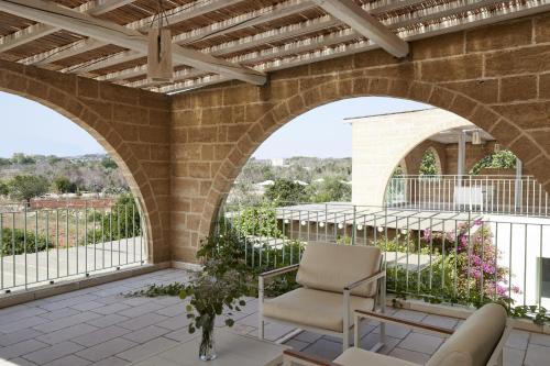 an outdoor patio with an archway and a chair at Montiro' Hotel in Leuca